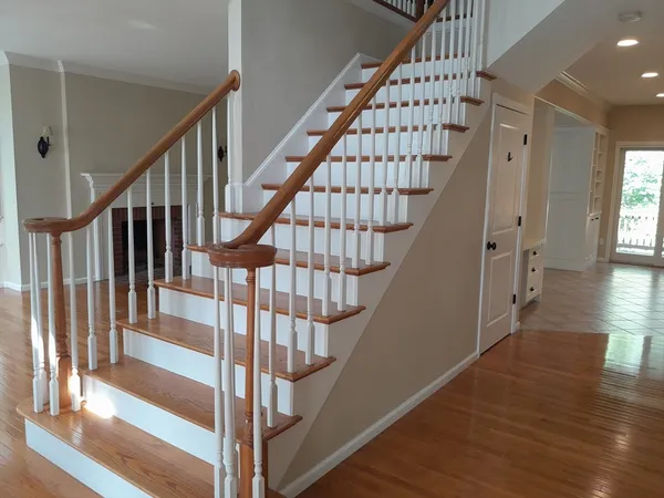 a view of staircase with wooden floor and white walls