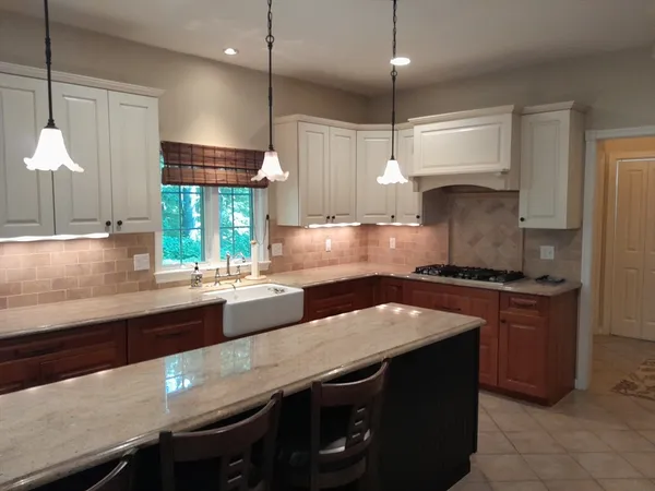 a kitchen with granite countertop a sink a counter space appliances and cabinets