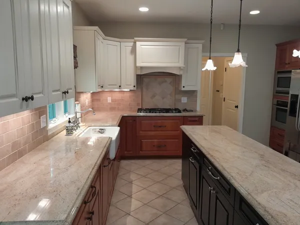 a kitchen with granite countertop a sink stove and cabinets