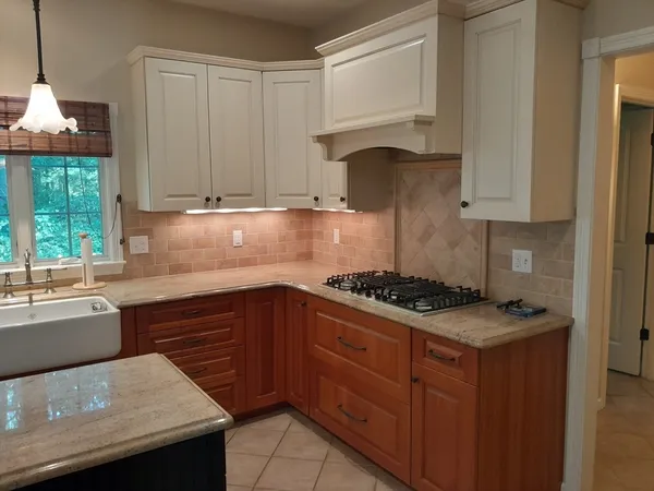 a kitchen with granite countertop a stove a sink dishwasher and cabinets with wooden floor