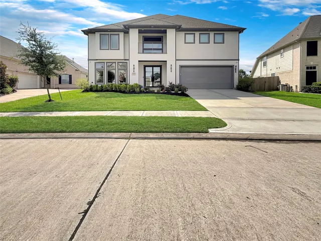a front view of a house with a yard and trees