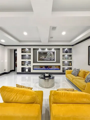 a living room with stainless steel furniture and kitchen view
