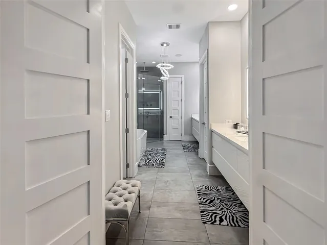 a bathroom with a glass door shower a sink and a mirror