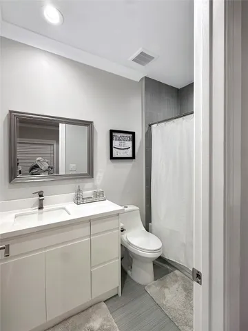 a bedroom with a bed and a flat tv screen on dresser
