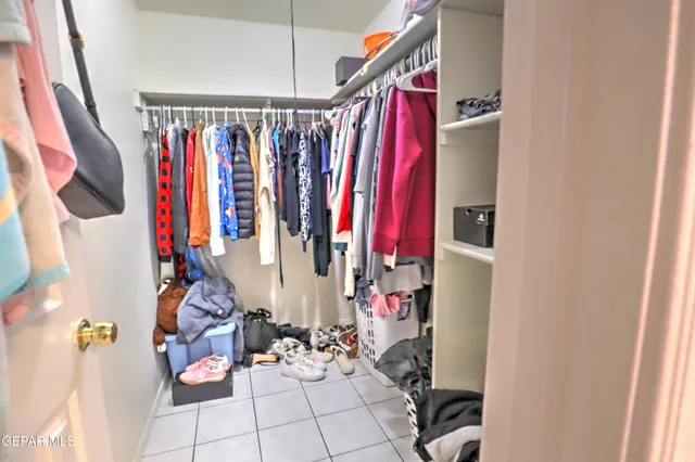 a view of walk in closet with clothes and shoes