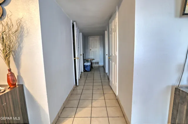 a view of a hallway with wooden floor and a bathroom