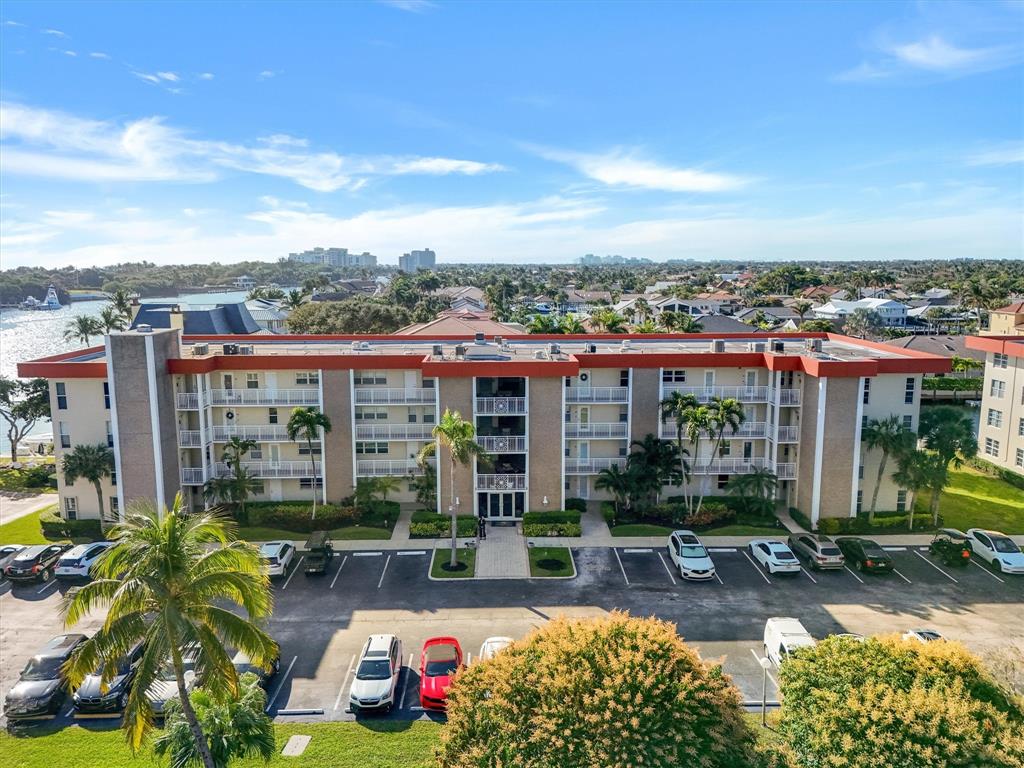 3050 Northeast 48th Court, Unit 401 Lighthouse Point, FL 33064 - Photo 4 of 53 a view of a patio with table and chairs potted plants and palm trees