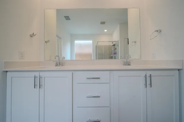a bathroom with a double vanity sink and mirror