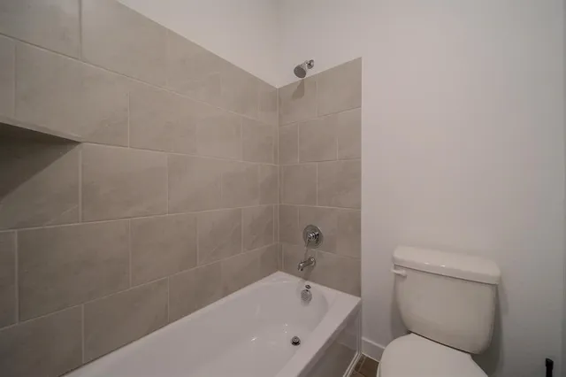 a white bath tub sitting next to a toilet
