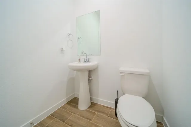 a bathroom with a sink toilet and a mirror