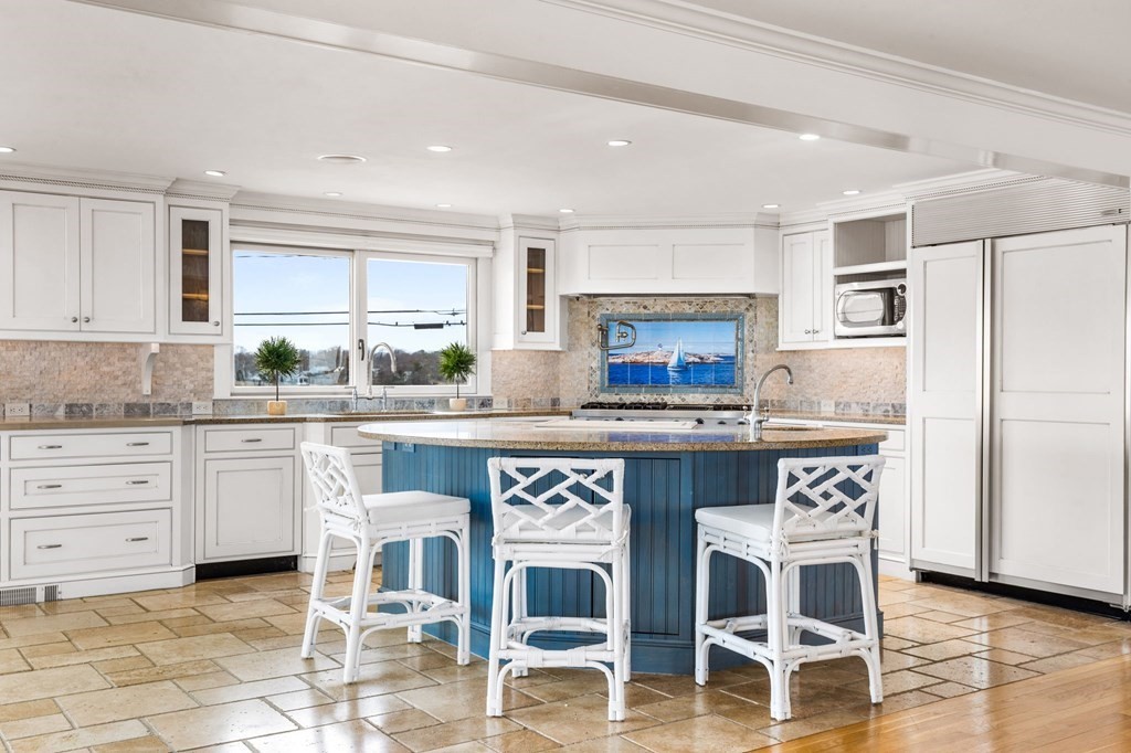 67 Surfside Road Scituate, MA 02066 - Photo 11 of 41 a kitchen with granite countertop a table chairs stove microwave and cabinets