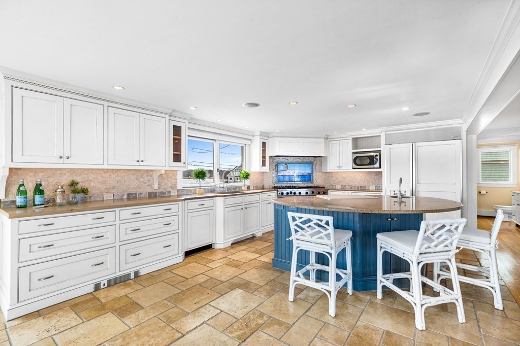 67 Surfside Road Scituate, MA 02066 - Photo 8 of 41 a kitchen with stainless steel appliances granite countertop a table chairs sink and cabinets