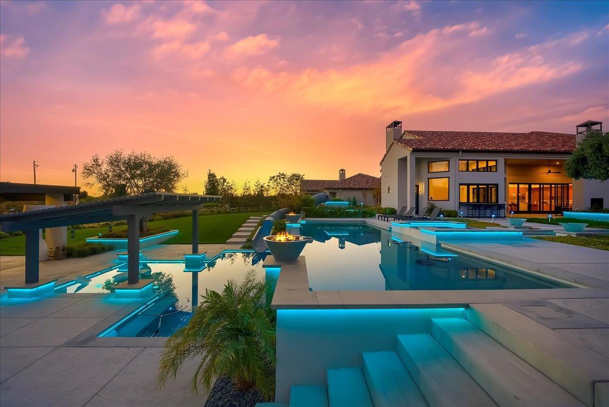 a view of a house with pool and chairs