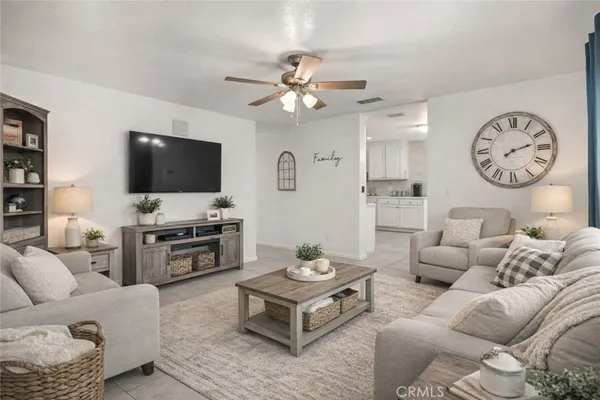 a living room with furniture a flat screen tv and kitchen view
