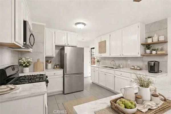 a kitchen with a refrigerator a stove a sink and cabinets