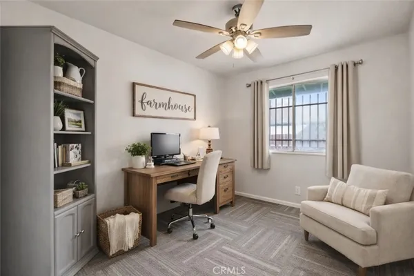 a view of a livingroom with workspace and a window