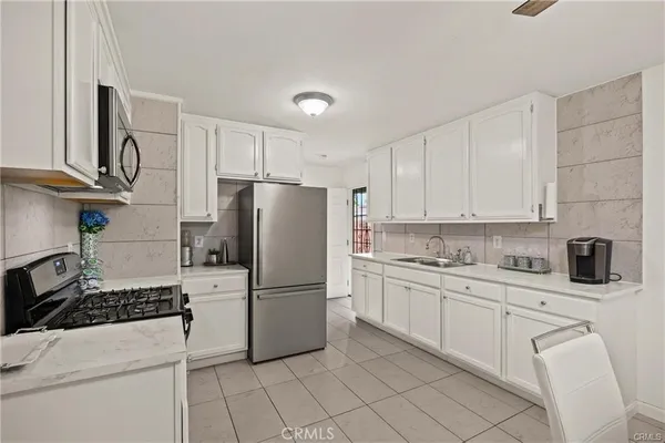 a kitchen with cabinets stainless steel appliances and a sink