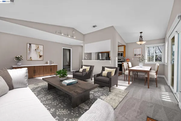 a living room with furniture and view of kitchen