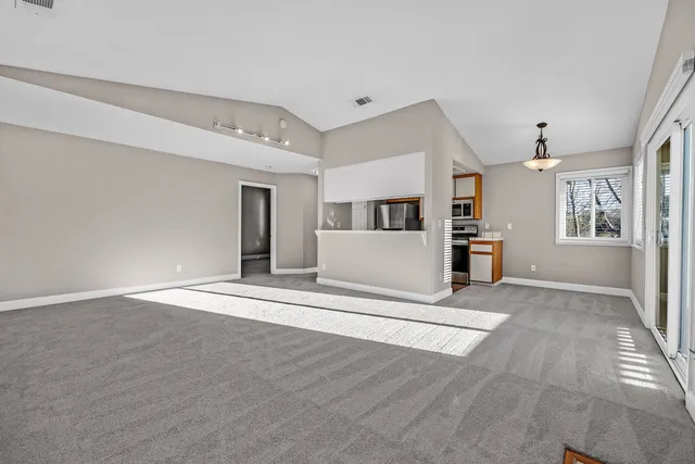 a view of livingroom with hardwood floor and a kitchen