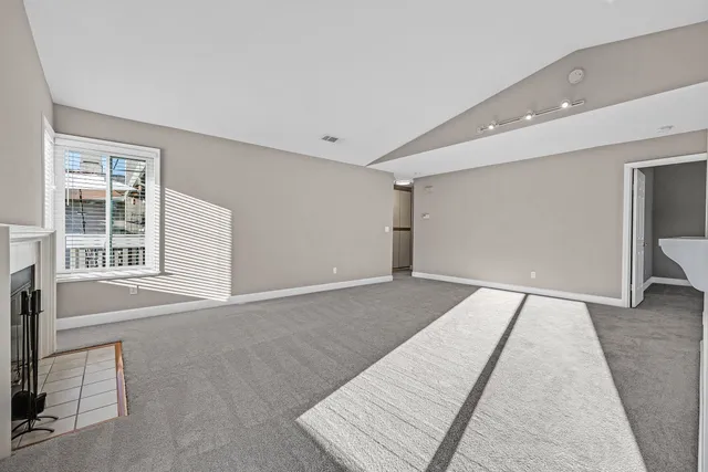 an empty room with fireplace and windows