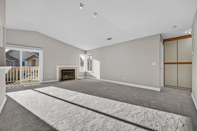 an empty room with a fireplace and a flat screen tv