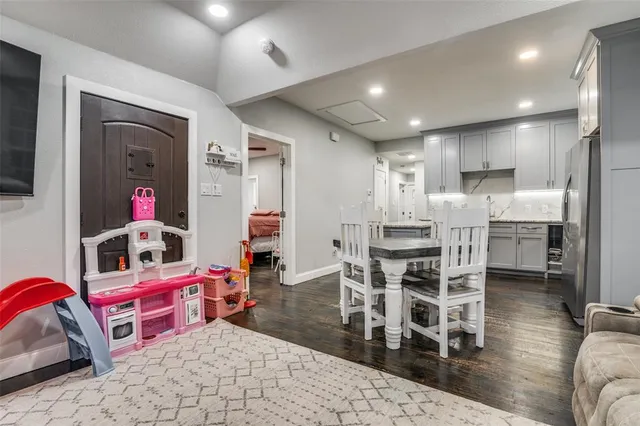 a living room with furniture a wooden floor and a kitchen view