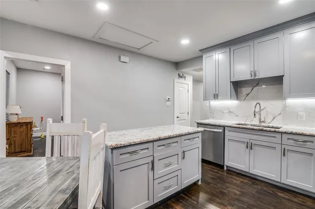 a kitchen with granite countertop a stove and cabinets