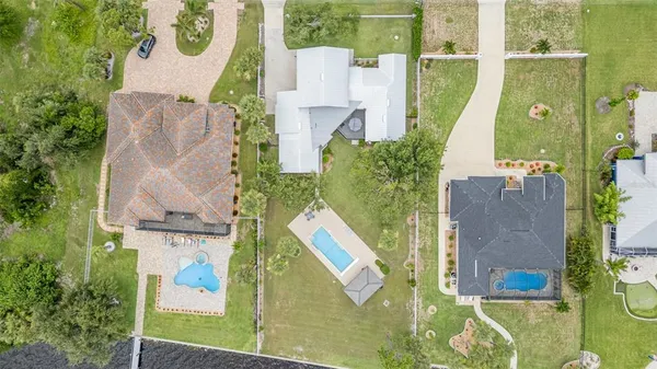 an aerial view of a house with a garden and lake view