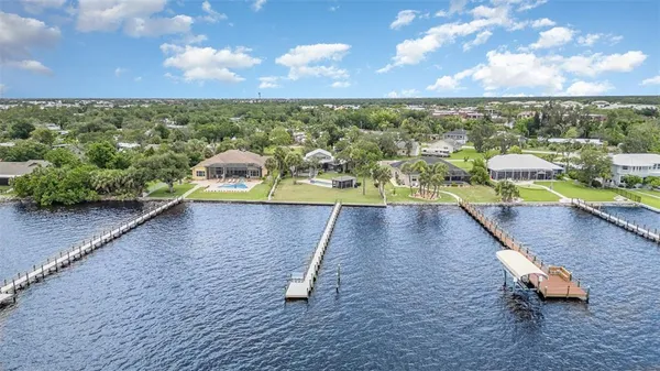 an aerial view of a house with a yard and lake view