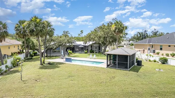 an aerial view of a house with a yard and lake view