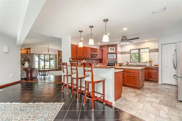 a kitchen with stainless steel appliances granite countertop a kitchen island a stove a sink a dining table and chairs
