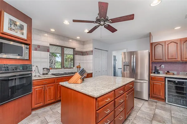 a kitchen with stainless steel appliances granite countertop a stove a sink and a microwave