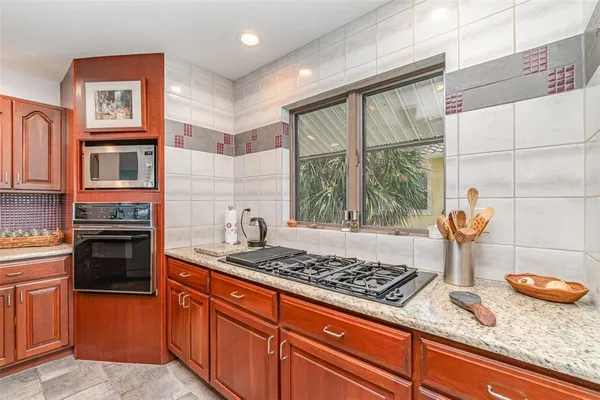 a kitchen with stainless steel appliances granite countertop a refrigerator and a stove top oven