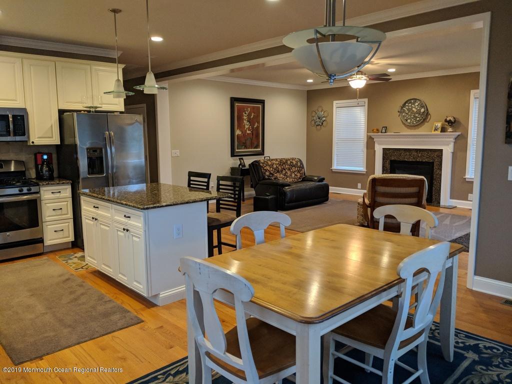 611 Riverside Drive Bayville, NJ 08721 - Photo 12 of 22 a kitchen with a table chairs refrigerator and microwave