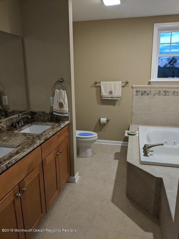 611 Riverside Drive Bayville, NJ 08721 - Photo 18 of 22 a bathroom with a granite countertop sink a mirror and a toilet