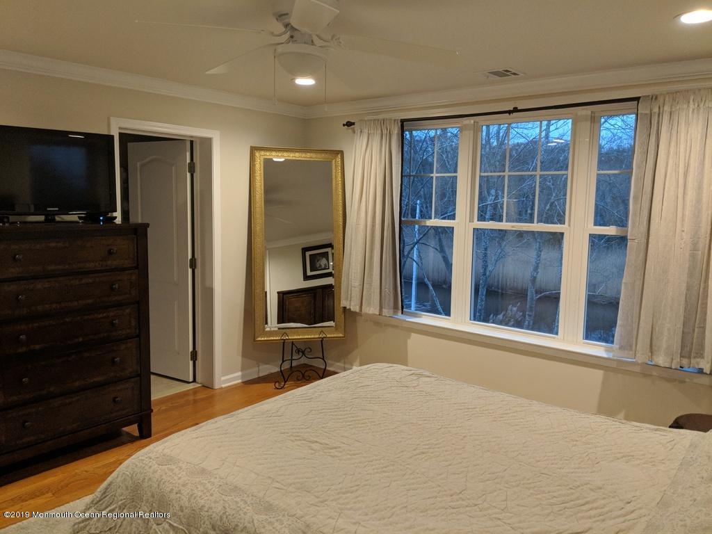611 Riverside Drive Bayville, NJ 08721 - Photo 19 of 22 a bedroom with a bed and a flat screen tv