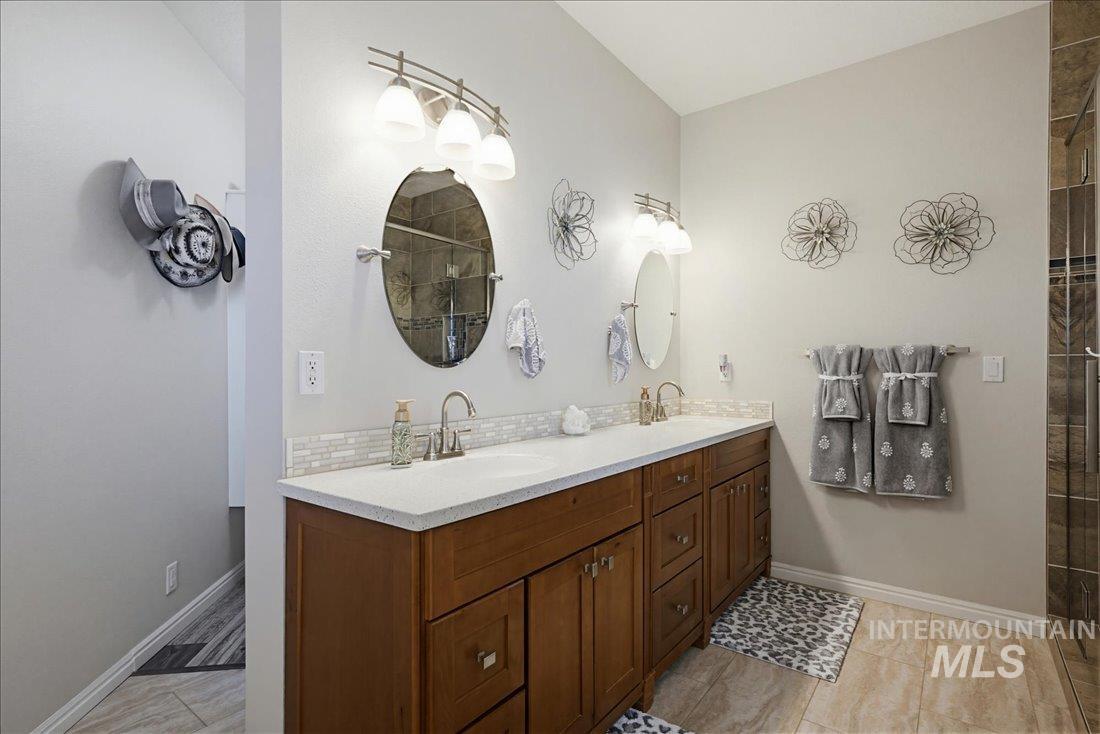 24623 Falcon Lane Caldwell, ID 83607 - Photo 20 of 40 Double vanity with wood-finish cabinetry and white countertops