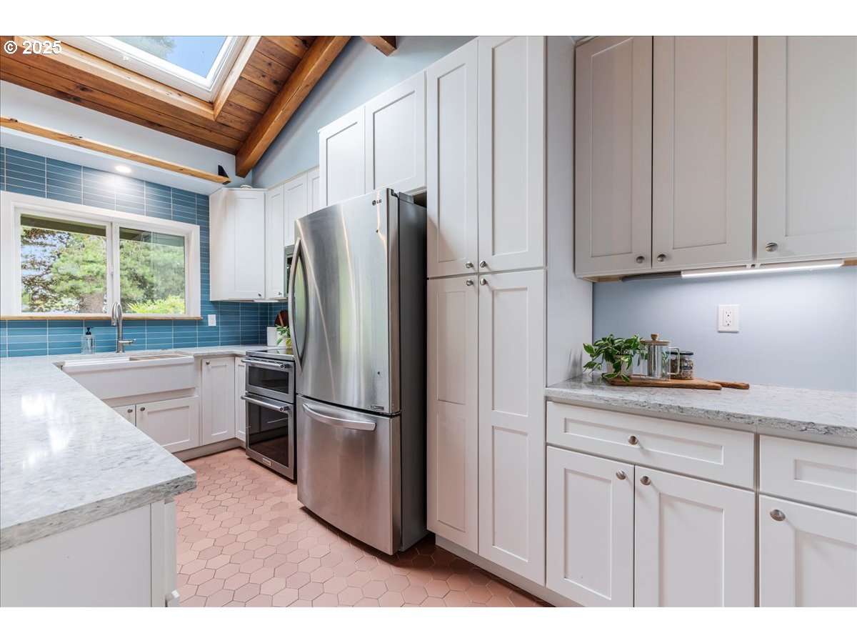 11805 Southwest Belvidere Place Portland, OR 97225 - Photo 14 of 44 a kitchen with stainless steel appliances granite countertop a refrigerator sink and cabinets