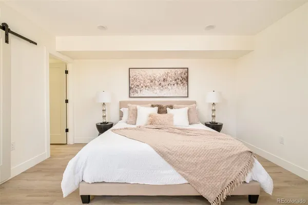 a bedroom with a bed and a painting on the wall