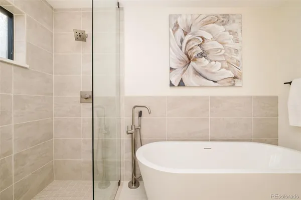 a white bath tub sitting next to a white wall