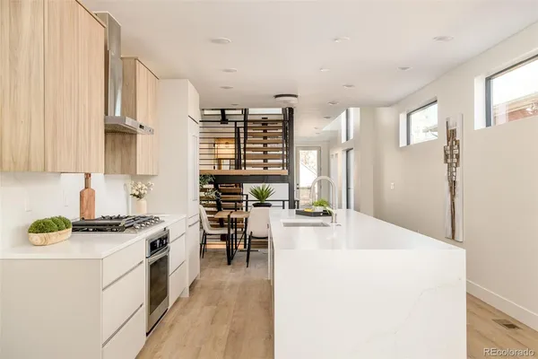 a kitchen with stainless steel appliances a stove a sink cabinets and a refrigerator