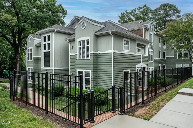 a front view of a house with iron fence