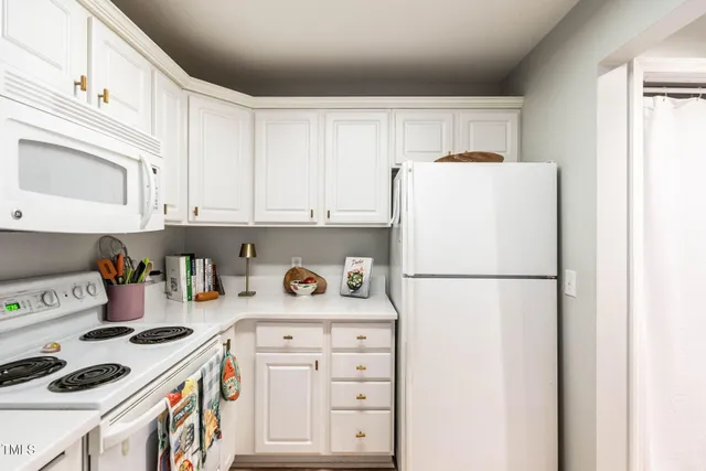 a kitchen with a refrigerator a stove a sink and cabinets