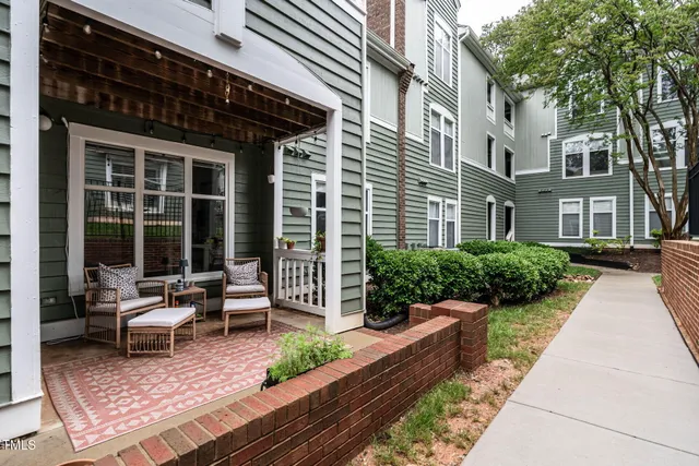 a view of a house with backyard and sitting area