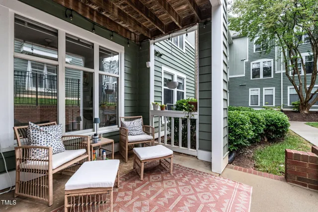 a roof deck with table and chairs and potted plants