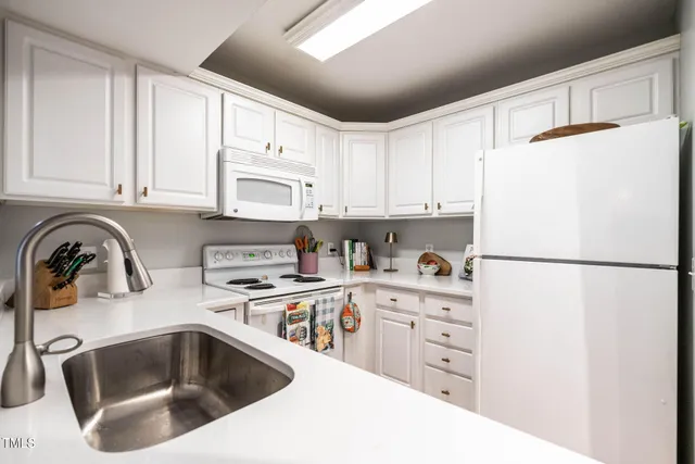 a kitchen with granite countertop a refrigerator sink and cabinets