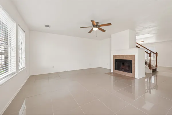 an empty room with windows and ceiling fan