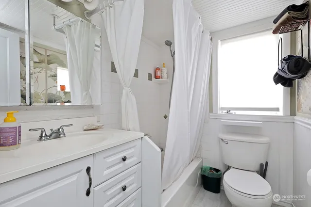 a bathroom with a sink a toilet and a window