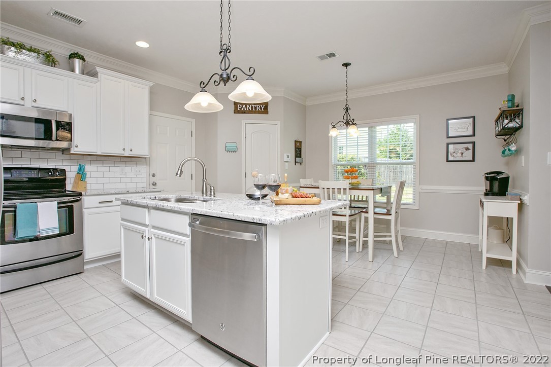 71 Germantown Road Cameron, NC 28326 - Photo 11 of 36 a kitchen with stainless steel appliances kitchen island granite countertop a sink and cabinets