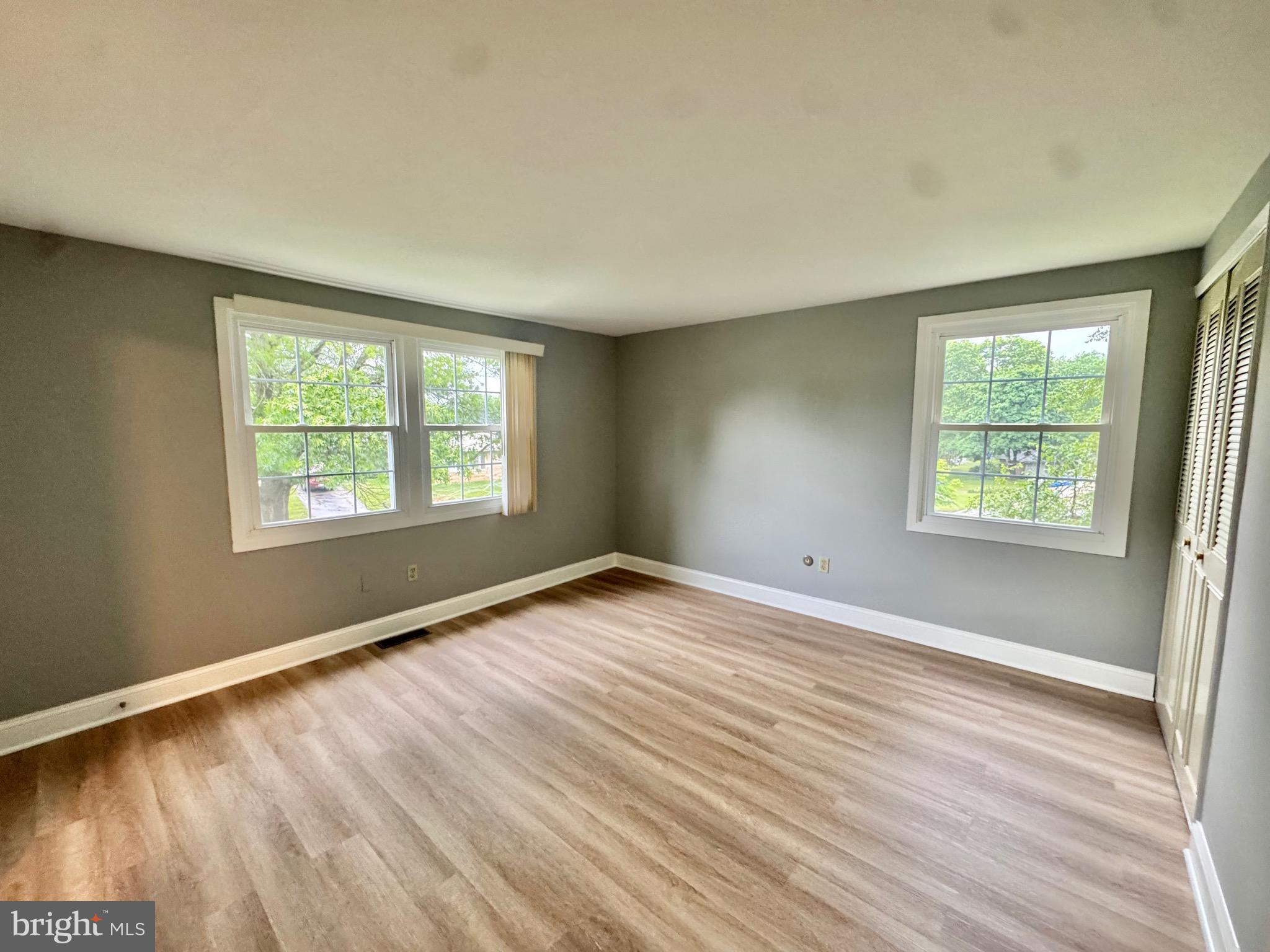 4908 Rocky Spring Lane Bowie, MD 20715 - Photo 20 of 36 an empty room with wooden floor and windows